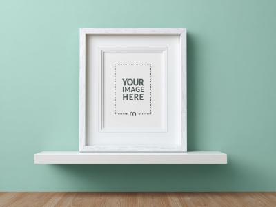 White Frame Mockup on Shelf Against Light Green Wall