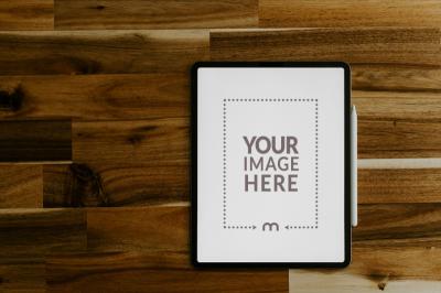 Top View iPad Mockup with Stylus on Wooden Background