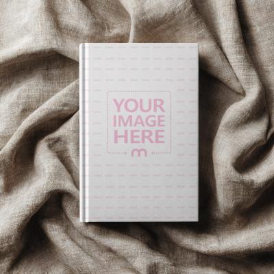 Top View of Book Cover Mockup on Elegant Clothing