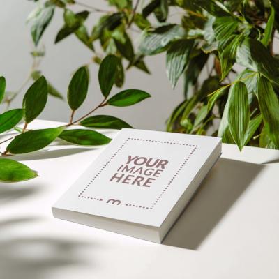 Paperback Book Cover Mockup on Table with Leaves