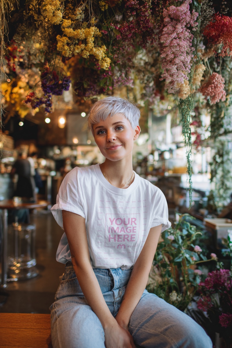 T-Shirt Mockup with Woman in Cafe-Themed Scene and Colorful Decor T-Shirt Mockup with Woman in Cafe-Themed Scene and Colorful Decor preview image