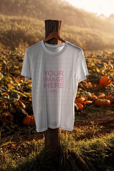 T-Shirt Mockup Hanging on Pole in Pumpkin Field for Halloween Scene