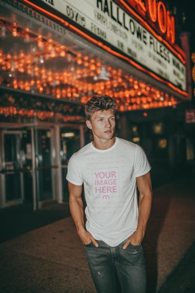 T-Shirt Mockup with Man Posing under Lights for Halloween Mood