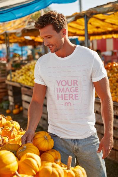 T-Shirt Mockup with Man Picking Pumpkin at Market for Halloween Look