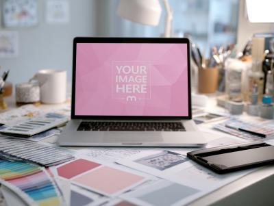 Laptop Mockup on Messy Designer Workspace Table in Creative Studio