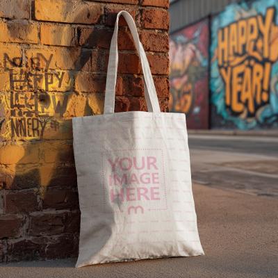 Tote Bag Mockup Against Brick Wall with Graffiti Art