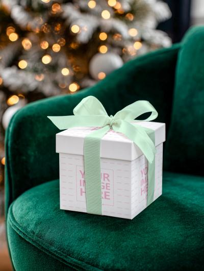 Gift Box Mockup on Velvet Green Chair with Christmas Tree Bokeh