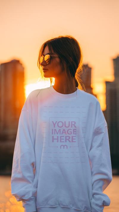 Sweatshirt Mockup Worn by Model Backlit at Sunset