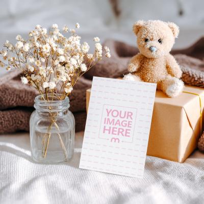 Card Mockup Placed in Front of Gift with Teddy Bear
