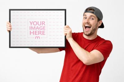 Framed Poster Mockup Held by Smiling Man for Advertising