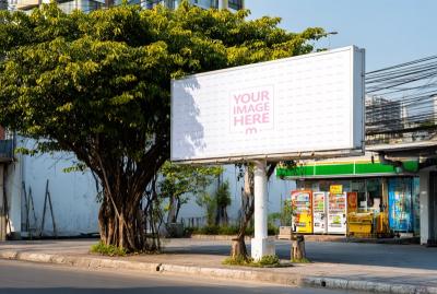 Large Horizontal Outdoor Billboard Mockup Next to Lush Tree